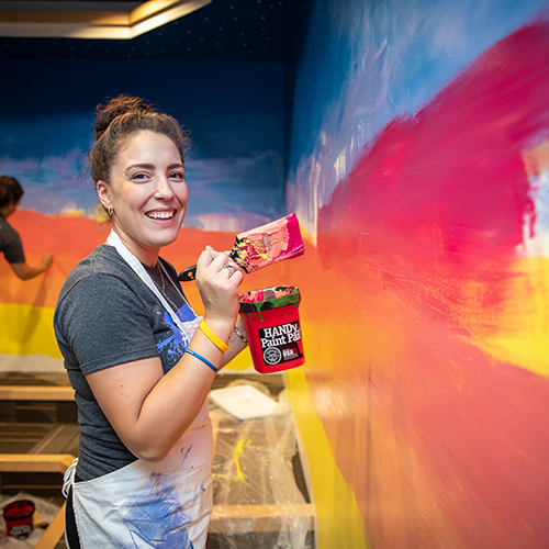 Hallmark employee painting wall at United Way Center.